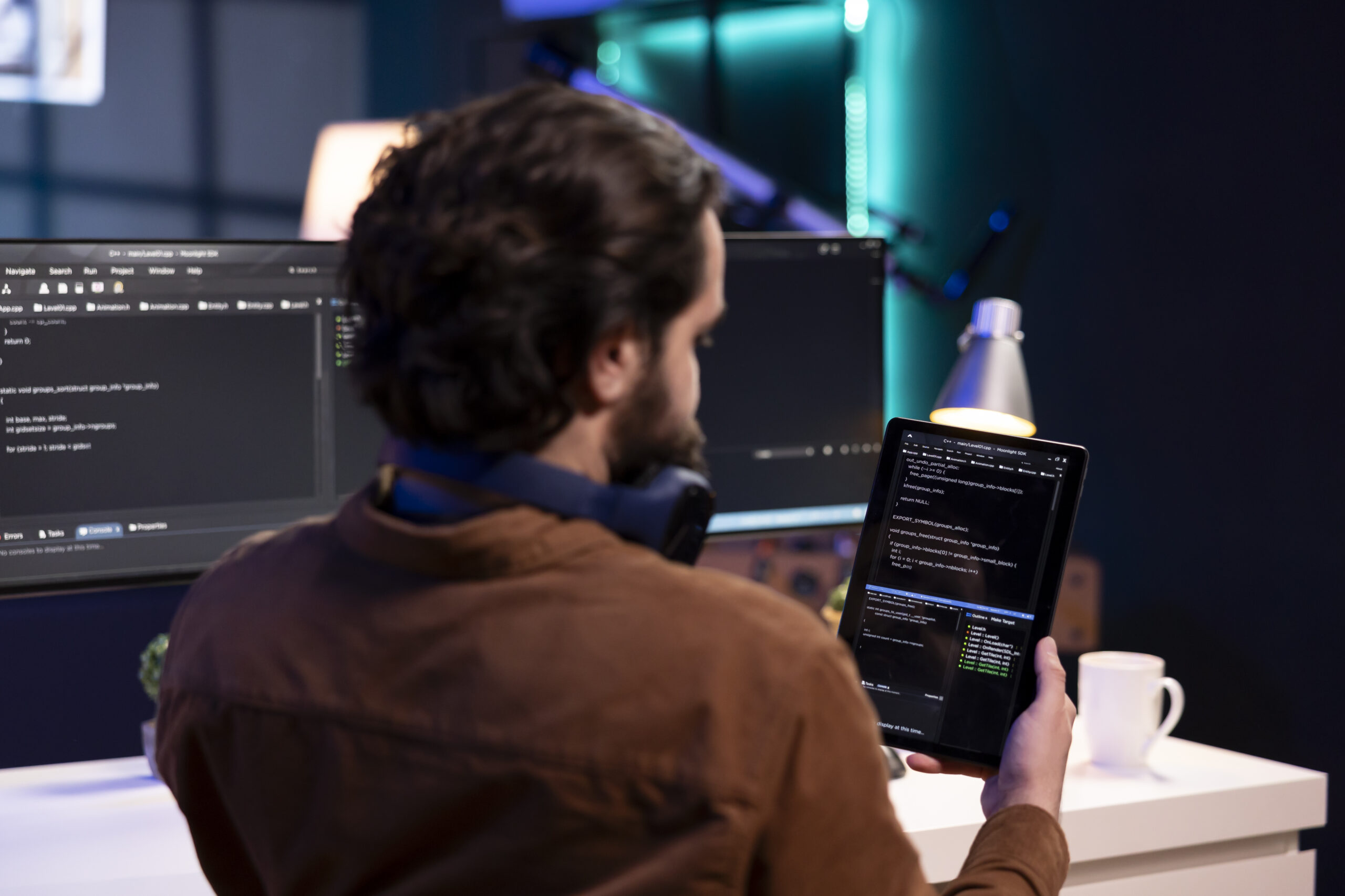 Man doing software quality assurance using tablet, reading source code before implementing it. Programmer inspecting coding on portable device, looking to fix potential bugs